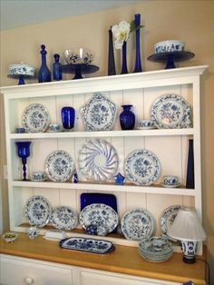 blue and white china is displayed on a shelf in the dining room, with other dishes