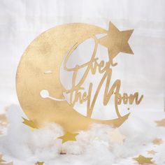 a cake topper that says over the moon with stars around it on some snow