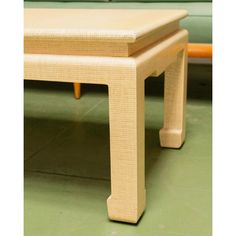 a small wooden table sitting on top of a green floor