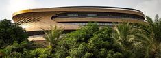 the circular building is surrounded by trees and bushes