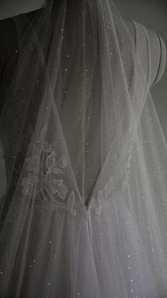 the back of a wedding dress with sequins on it