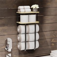 there is a shelf that has several rolls of toilet paper on it and a vase with flowers