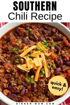 a bowl filled with chili and cheese on top of a red checkered table cloth