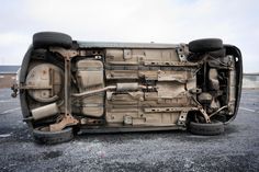 the front end of a car that is sitting in a parking lot with it's door open