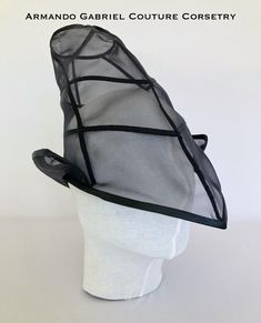 The Wicked Witch is one of the most iconic characters from the Wizard of Oz universe. This headdress in black mesh, complete with visor, will add a classy touch to any costume or outfit, creating an inspired yet fashion forward look. The item will fit a standard head circumference of 56cm - 58 cm. Black Witchy Hat For Halloween, Witchy Brimmed Costume Hats For Parties, Black Gothic Hat For Costume, Black Gothic Hat For Cosplay, Witchy Wide Brim Costume Hat For Party, Black Witchy Brimmed Costume Hat, Fitted Black Witchy Hat, Black Fitted Witchy Hat, Witchy Black Brimmed Costume Hat