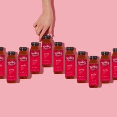 a woman's hand reaching for bottles of honey on a pink background with the words, mother's pantry