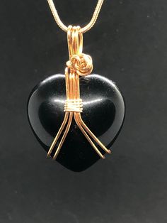 "Black Obsidian heart crystal necklace. Beautiful, dreamy new moon darkness high-quality obsidian heart shaped stone. Lovingly wrapped in your choice of high-quality tarnish resistant gold colored brass or silver colored wire.    Set with matching color 18\" or 20\" gold plated snake chain necklace.  Obsidian is volcanic glass that forms naturally. It comes from the rapid cooling of felsic lava.  Mystical Properties: Black Obsidian is believed to be a powerful tool for those seeking protection, Black Heart-shaped Gemstone Jewelry, Gift Obsidian Necklaces With Natural Stones, Gift Obsidian Necklace With Natural Stones, Obsidian Natural Stones Necklace For Gift, Handmade Obsidian Jewelry As A Gift, Handmade Obsidian Jewelry Gift, Spiritual Black Heart-shaped Necklace, Black Hand Wrapped Necklace For Gift, Hand Wrapped Black Necklace For Gift