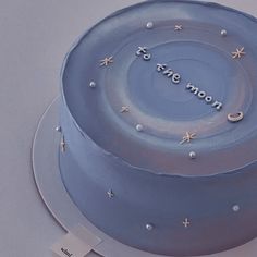 there is a blue cake with stars and moon decorations on the top that says to the moon