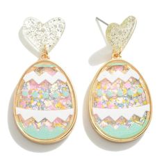 two pairs of earrings with glitter in the shape of an egg and heart on top