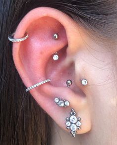 a woman's ear with three different piercings