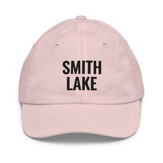 Crafted for comfort and designed for those who love Smith Lake, this embroidered youth-sized hat is sure to become an essential to all your outdoor adventures. Featuring an adjustable strap, it offers a great fit, comfort, and a stylish design. • 100% bio-washed chino cotton twill• Head circumference: 21″–21.57″ (53.3 cm–54.8 cm)• Unstructured, 6-panel, low-profile• Adjustable self-fabric hideaway strap closure• Brass-toned tri-glide buckle• Blank product sourced from Bangladesh Tag us on Instag Adjustable Sports Dad Hat With Embroidered Logo, Dad Hat With Letter Print For Outdoor, Outdoor Dad Hat With Letter Print And Curved Bill, Outdoor Baseball Cap With Embroidered Logo And Flat Brim, Curved Bill Dad Hat With Letter Print For Outdoor, Outdoor Flat Brim Baseball Cap With Embroidered Logo, Adjustable Fit Flat Bill Baseball Cap For Outdoor Activities, Adjustable Sporty Baseball Cap For Camping, Basic Outdoor Cap