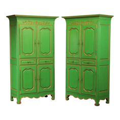 two tall green cabinets with ornate carvings on the doors and bottom, both painted bright green