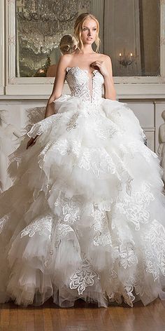 a woman in a white wedding dress standing on a wooden floor next to a window