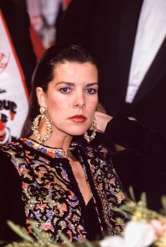 a woman wearing large gold earrings sitting at a table