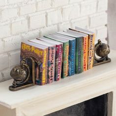 a row of books sitting on top of a white mantle