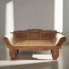 a wooden bench sitting on top of a floor next to a white wall and windows