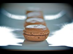 a row of chocolate macaroons sitting on top of a white plate