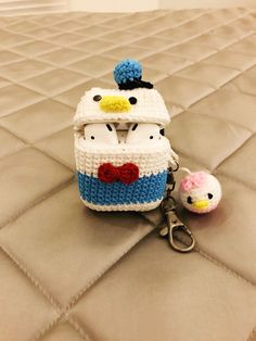 a crocheted hello kitty purse and keychain sitting on top of a bed