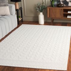 a living room with a white rug on the floor