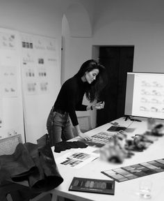 a woman standing over a table with pictures on it