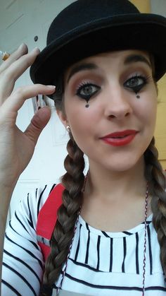 a woman with long braids wearing a black hat and striped shirt is posing for the camera