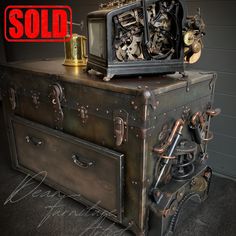 an old trunk is sitting on top of it's side with a sold sign above it