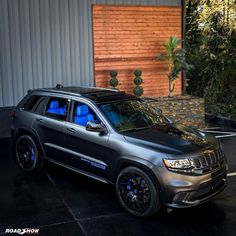 a grey jeep parked in front of a building