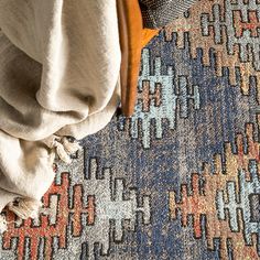 an area rug with various colors and patterns on it, including blue, red, yellow, orange, and white