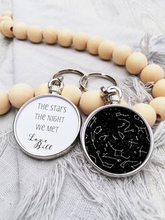 two keychains with words on them sitting next to a bead necklace that says true stars the night we met