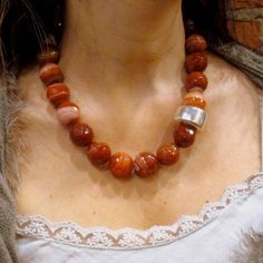 "This is a stunning statement necklace. Dark orange, white and light brown tones agate stones create a very unique piece. The beads are round and faceted, giving a shiny look to this piece (approx. 2 cm diameter). Agate's most noticeable properties overall are balancing yin/yang energy, courage, protection, healing, and calming. Historically it was placed in water for cooking or drinking to dispel sickness. The Metaphysical and Healing Properties Lore of any specific type of agate depend to some Chunky Stone Necklace, Purple Stone Necklace, Cocktail Necklace, Red Coral Necklace, Necklace Orange, Orange Necklace, Big Necklace, Stone Statement Necklace, Stones Necklace