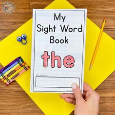 the sight word book is being held in front of some crayons and pencils