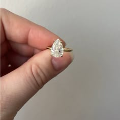 a person holding an engagement ring in their hand with the diamond on it's side