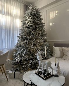 a living room with a christmas tree in the corner and decorations on the coffee table