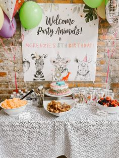 an animal themed birthday party with cake, snacks and balloons