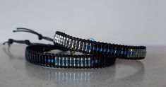 two black and silver bracelets with blue beads