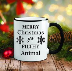 a black and white coffee mug with merry christmas ya filthy animal