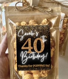 someone holding up a bag of popcorn with the number forty birthday sign in front of it