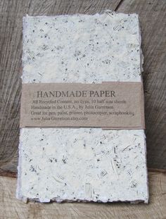 the handmade paper is sitting on top of a piece of wood