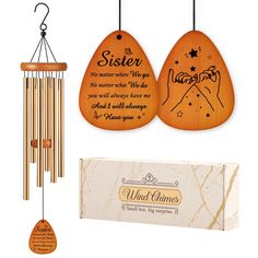 a wooden wind chime with an engraved message on it and a card for sister