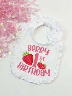 a bib that says berry st birthday next to pink streamers