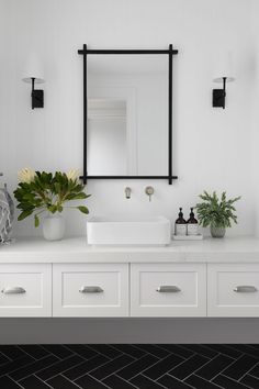 a bathroom with white cabinets and black accents