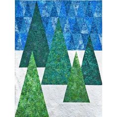 a quilted christmas tree pattern on a white background with blue and green trees in the middle