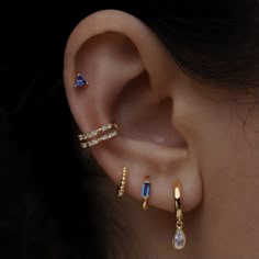 a woman's ear with three different types of piercings