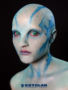 an alien man with blue paint on his face and chest, staring at the camera