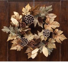 a wreath with pine cones, leaves and acorns