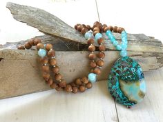 "Tranquility Mala Beads - Ocean Jasper & Sandalwood Beads - Hand Knotted - 108 Bead Mala - Length approx. 40\" The rhythmic cadence of the sea has always called humanity to its shores. This Ocean Jasper and Sandalwood Mala bead necklace from True Nature Jewelry brings that same spirit of peace and letting go. Hand knotted for flexibility and beauty, it features soothing and fragrant Sandalwood beads and Light Aqua Agate to help balance the emotions. A large Ocean Jasper pendant which brings Bohemian Natural Jewelry With 8mm Beads, Natural Bohemian Jewelry With 8mm Beads, Bohemian Natural 8mm Bead Jewelry, Earthy Beaded Necklace With 108 Beads For Healing, Meditation Beaded Necklace With Natural Stones, Bohemian Oval Beaded Necklaces For Meditation, Nature-inspired Beaded Necklaces With Round Natural Stones, Nature-inspired Hand-strung Beaded Necklaces For Healing, Nature-inspired Beaded Necklaces With Natural Stones