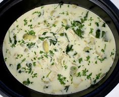 a black pan filled with food on top of a white stovetop burner and garnished with parsley