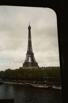 the eiffel tower towering over the city of paris as seen through a window