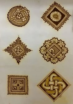 an assortment of decorative designs on a white plate with gold foil and black ink in the middle