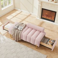 a pink couch sitting on top of a hard wood floor next to a fire place